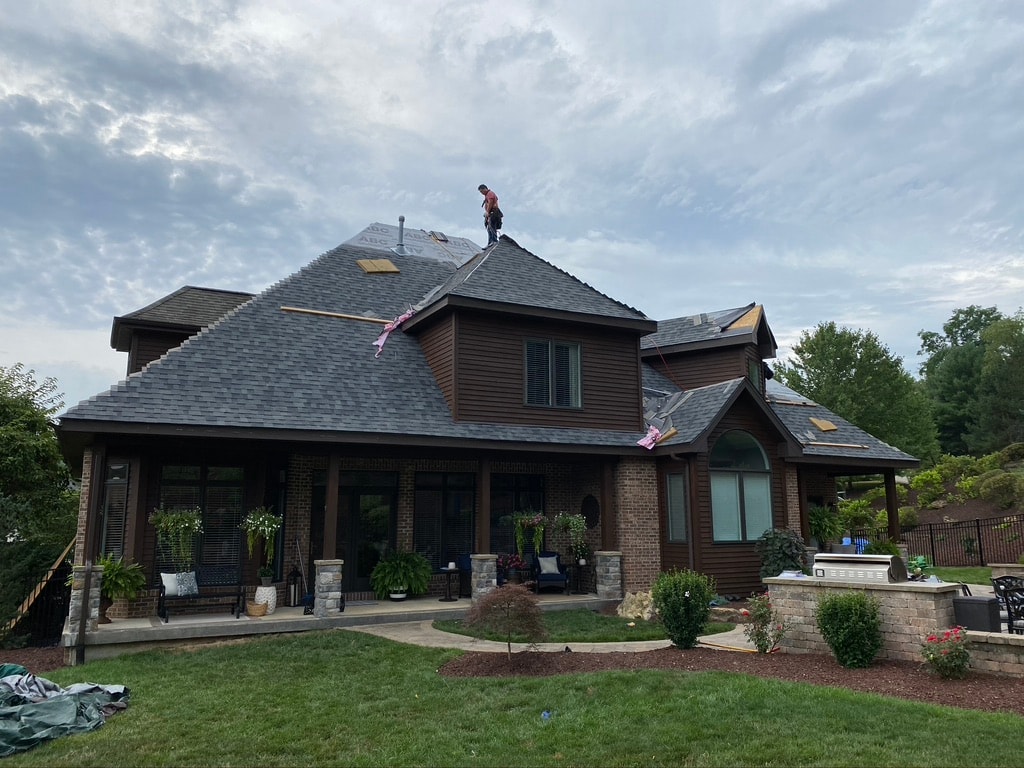 Rear view of home with Estate Grey shingles nearly complete on back roofline