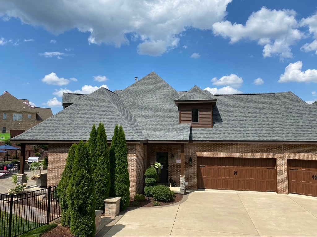 Completed new roof on side elevation showing garage and landscaping